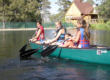 three girls paddling a canoe
